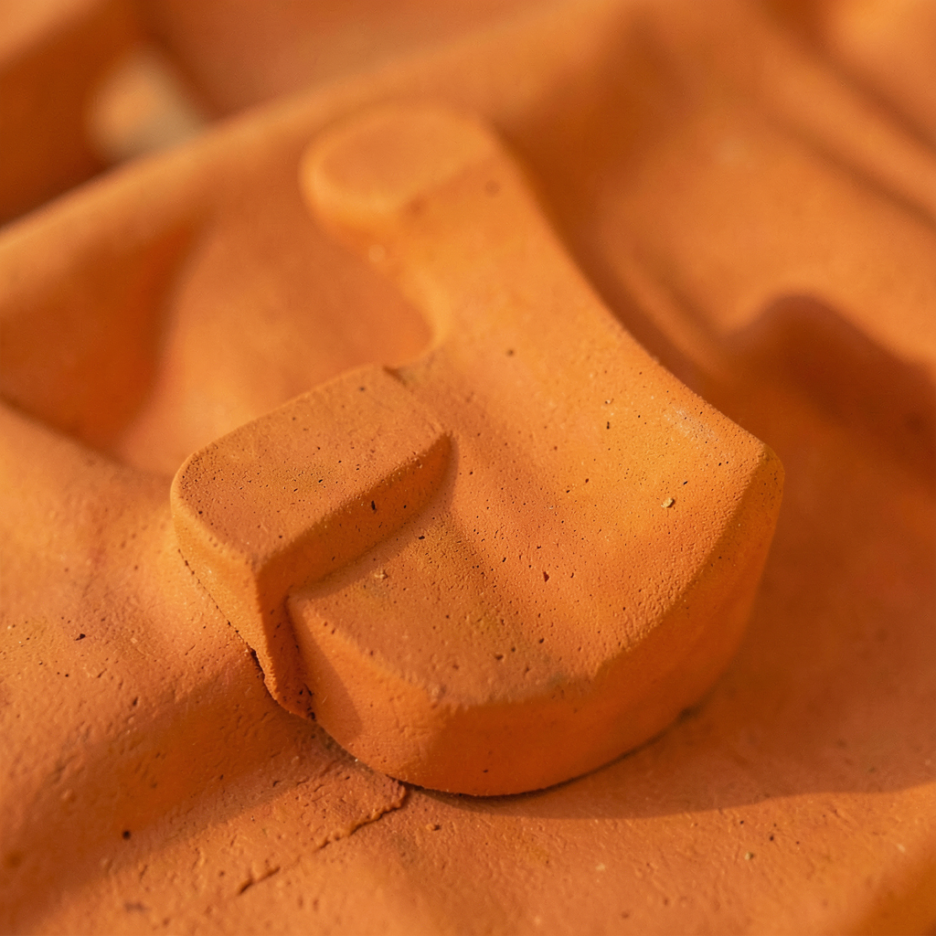 Détail de carreaux céramique terracotta mat texturés dans une salle de bain tendance et chaleureuse
